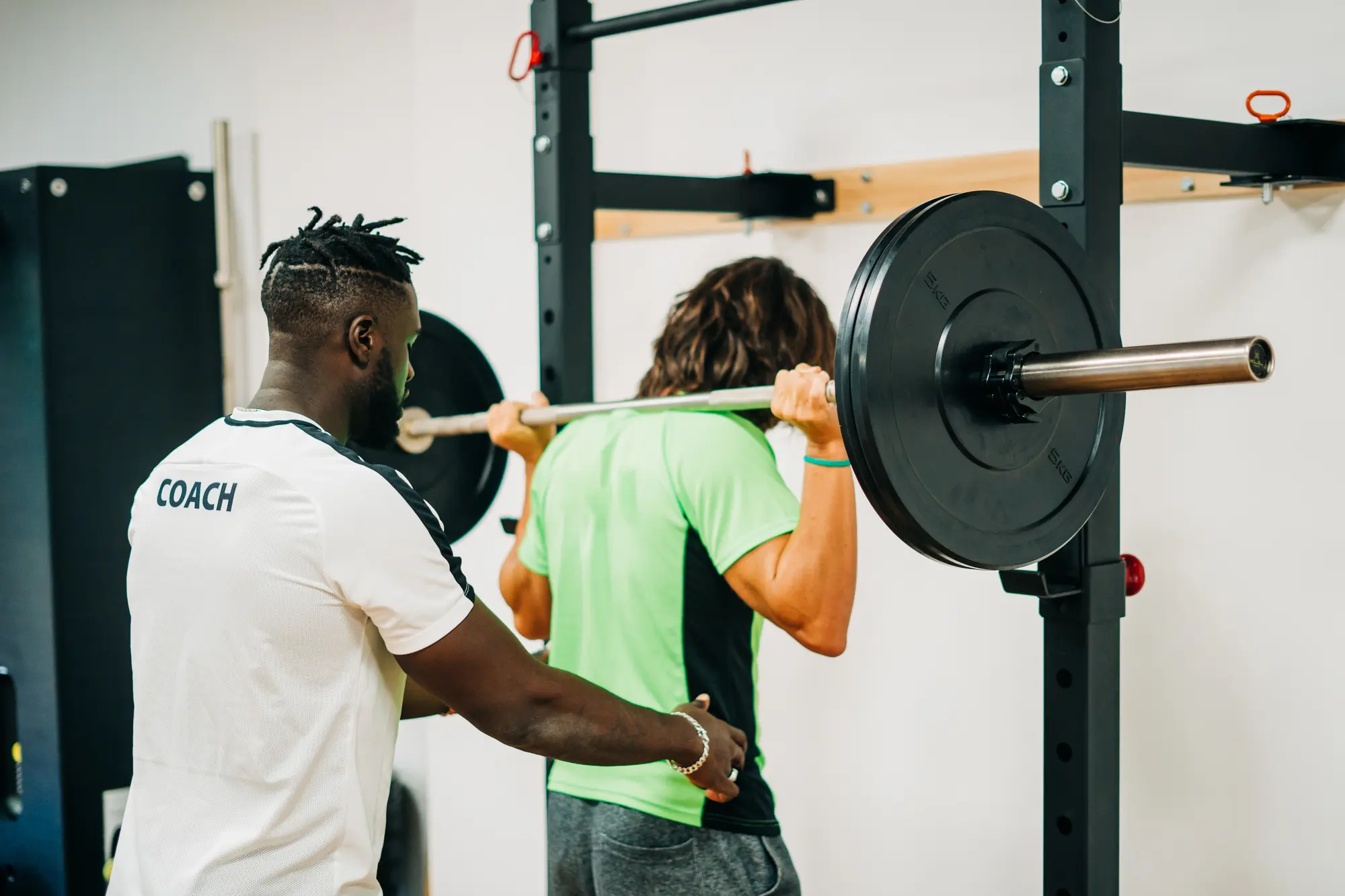 A coach spotting his client's squat