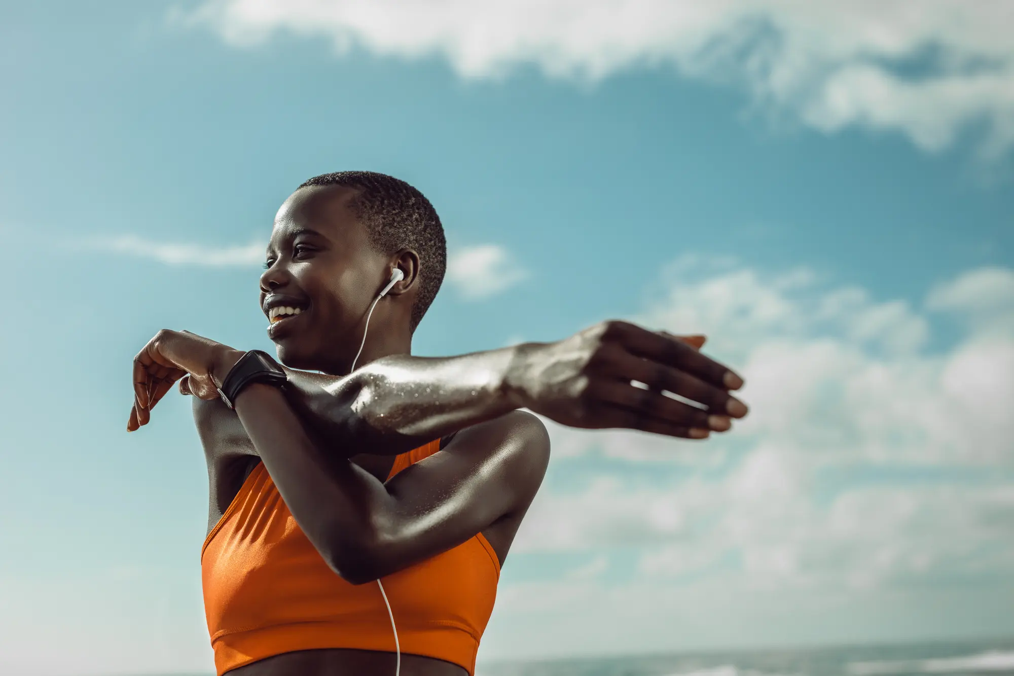 An athlete smiling as she stretches before a run